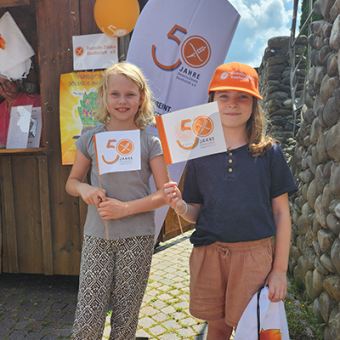 Zwei keline Mädcen mit DZG Mützen und Fähnchen