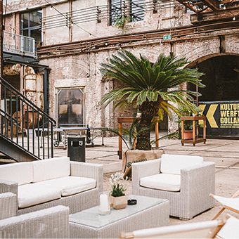 Außenbereich mit Palme und weißen Loungemöbeln