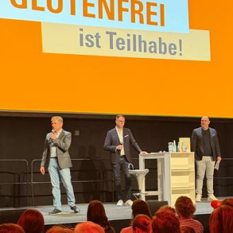 Gunnar Höckel begrüßt die Besucher. Dahinter steht Glutenfrei ist Teilhabe auf der Leinwand