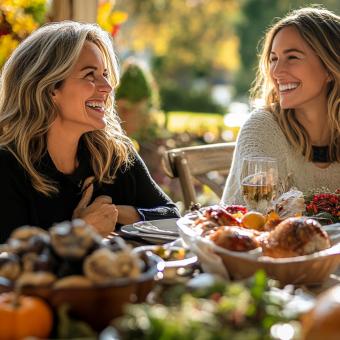 2 Frauen sitzen nebeneinander und genießen ihr Essen