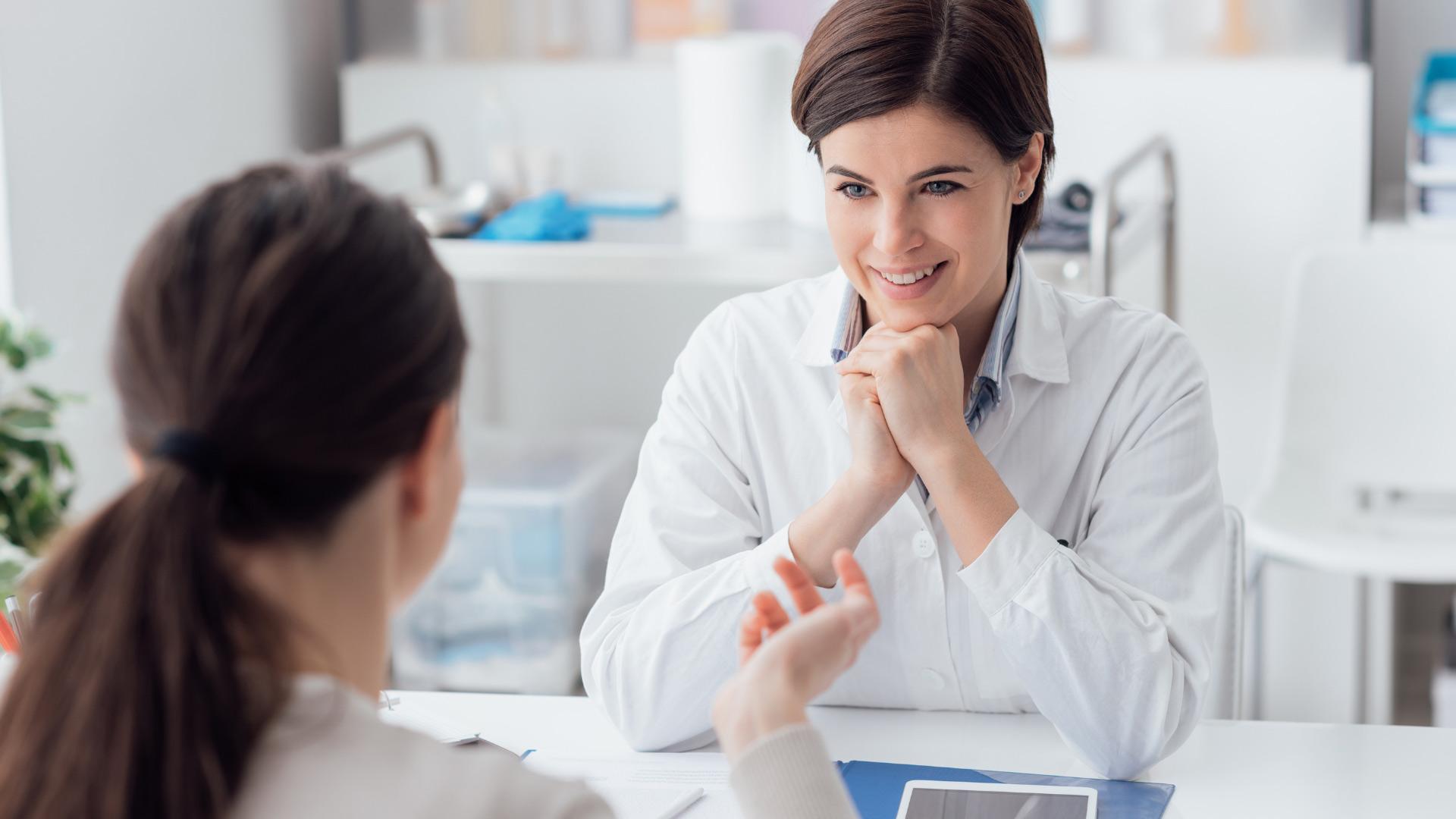 Im Sprechzimmer sitzen Ärztin und Patientin