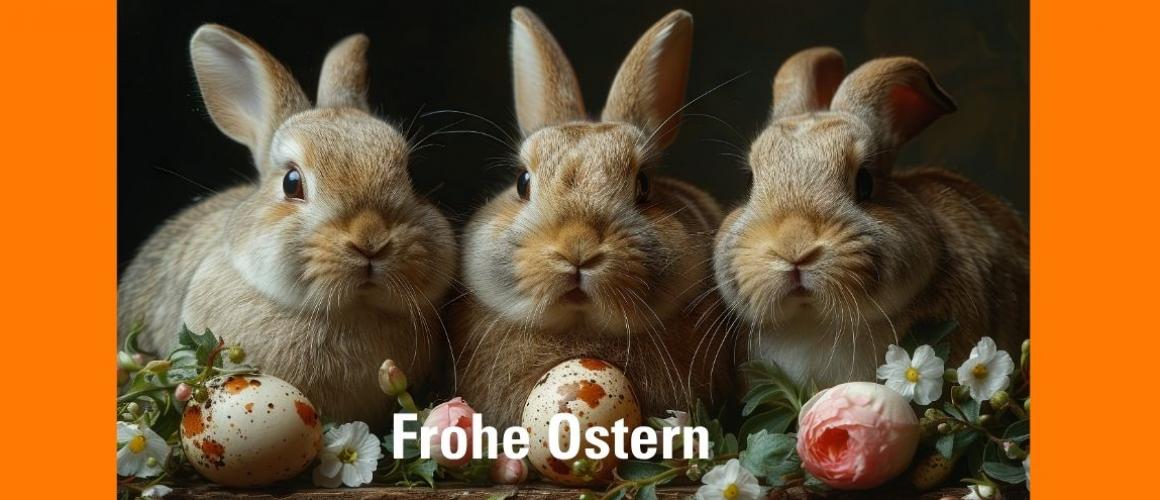 Drei Hasen sitzen eng nebeneinander und schauen in die Kamera. Um sie herum liegen Ostereier und Blumen. Darunter steht: Frohe Ostern