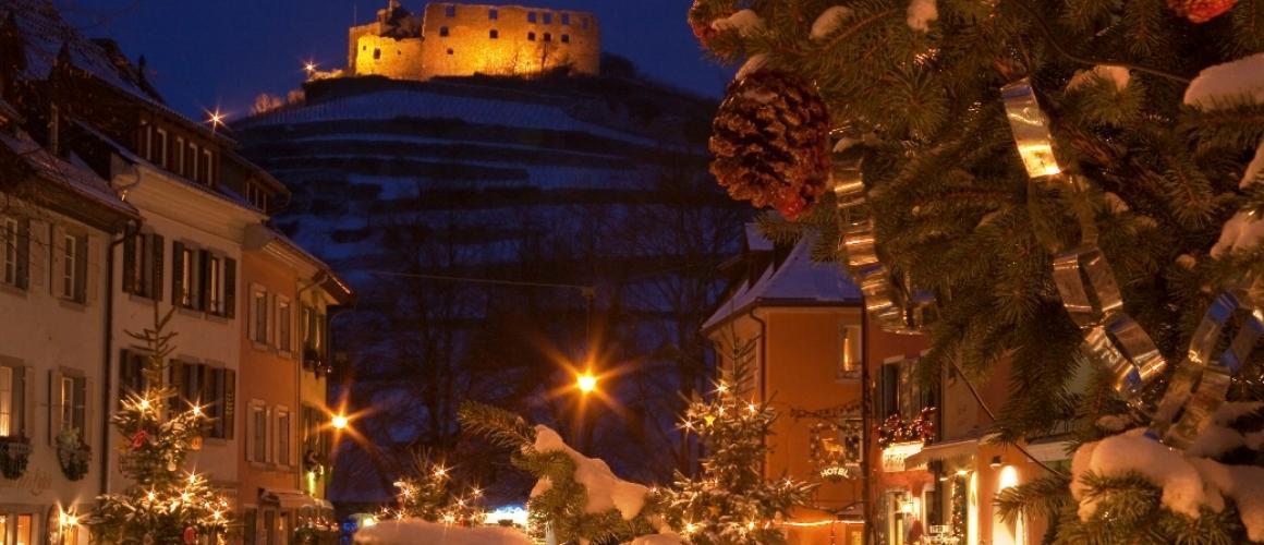 Winterliches Staufen mit geschmücktem Tannenbäumen und beleuchteter Burg