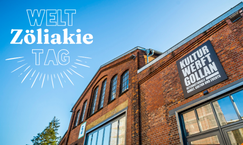 Aussenansicht der Kulturwerft Golan- ein altes Fabrikgebäude mit blauem Himmel - links oben ist das Logo der durchgestrichenen Ähre