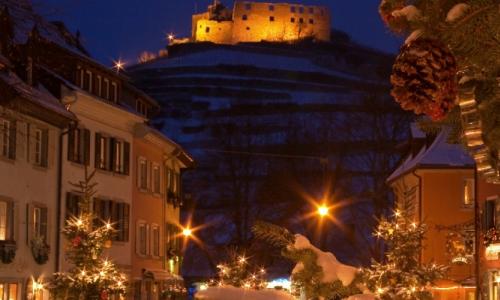 Winterliches Staufen mit geschmücktem Tannenbäumen und beleuchteter Burg